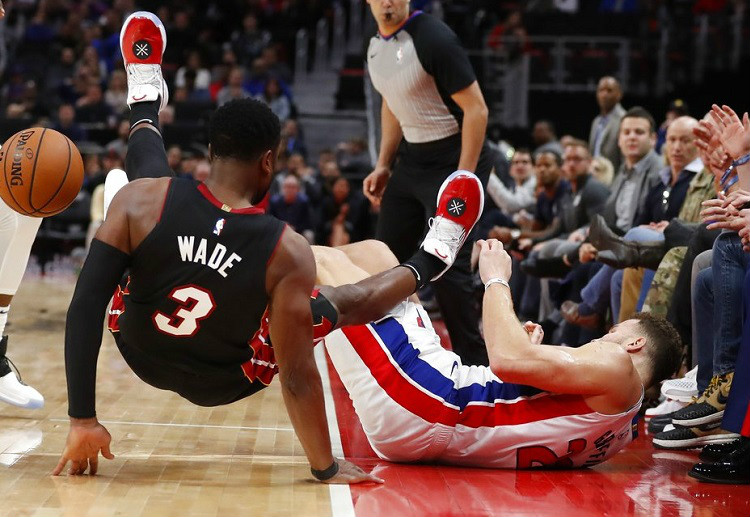 Dwyane Wade falls over Blake Griffin after they both chased the loose ball during the Heat-Detroit NBA game