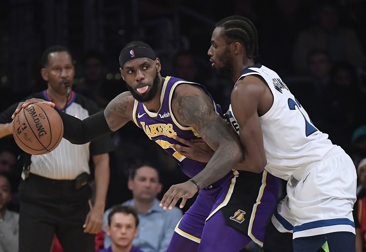 Lakers forward LeBron James tries to get by against NBA opponent Timberwolves forward Andrew Wiggins