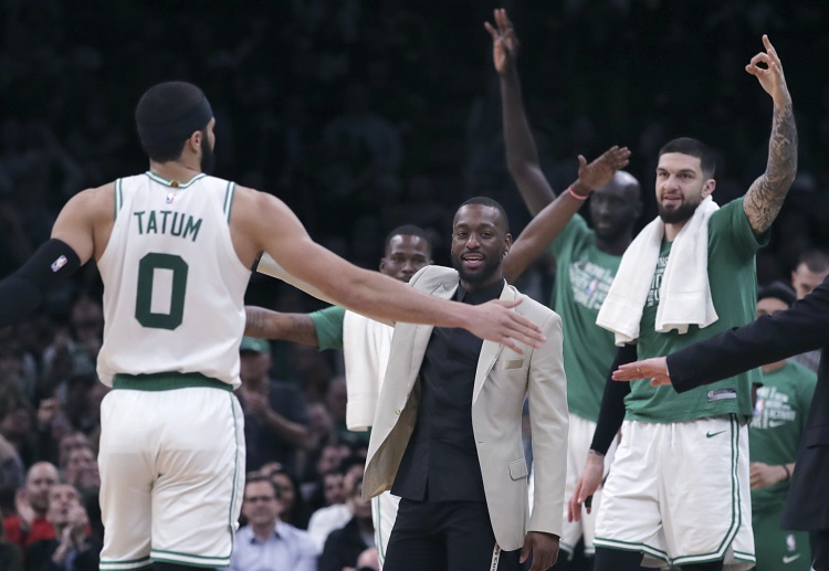 Injured Kemba Walker congratulates forward Jayson Tatum during Boston's NBA clash against Orlando